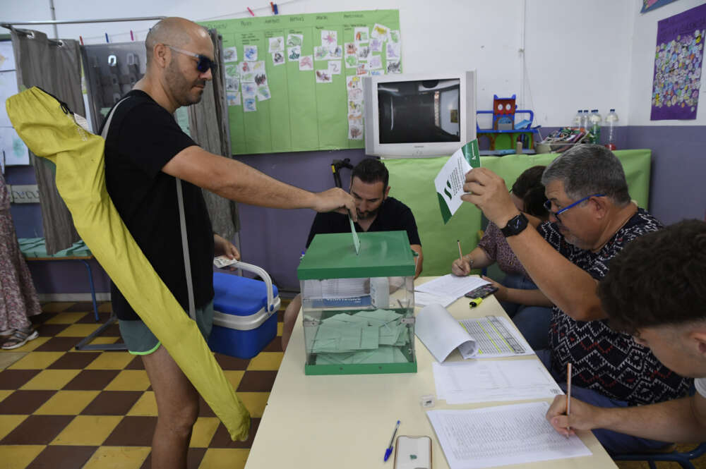 Un hombre cargado con nevera y sombrilla de playa ejerce su derecho al voto en el colegio Virgen del Mar de Almería hoy domingo 19 de junio cuando se han constituido una totalidad de 10.189 mesas electorales para los duodécimos comicios autonómicos andaluces. EFE/Carlos Barba