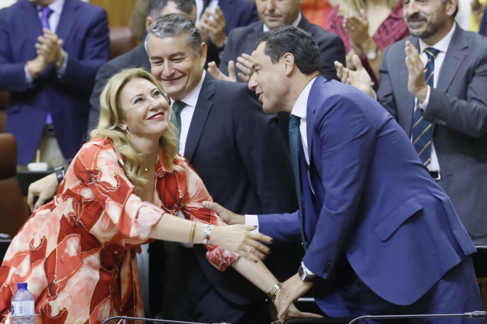 El presidente de la Junta de Andalucía, Juanma Moreno (d), felicita a la consejera de Economía, Hacienda y Fondos Europeos, Carolina España, en el pleno del Parlamento de Andalucía, donde este miércoles se ha convalidado, con los votos a favor de PP y Vox y el rechazo de toda la izquierda, la rebaja fiscal impulsada por Moreno. EFE/José Manuel Vidal