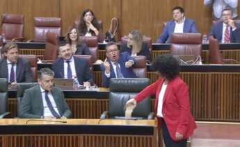 Maribel Mora, diputada de por Andalucía, vertiendo un jarro de arena en el escaño vacío del presidente Juanma Moreno.