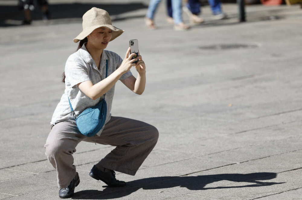 Una turista toma fotos con su teléfono móvil en Sevilla. EFE/Sebastián Mariscal