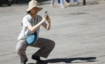 Una turista toma fotos con su teléfono móvil en Sevilla. EFE/Sebastián Mariscal