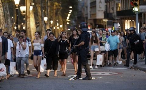 n grupo de gente se desplaza esta noche entre el despliegue policial en el lugar del atentado ocurrido por la tarde en Las Ramblas de Barcelona. EFE