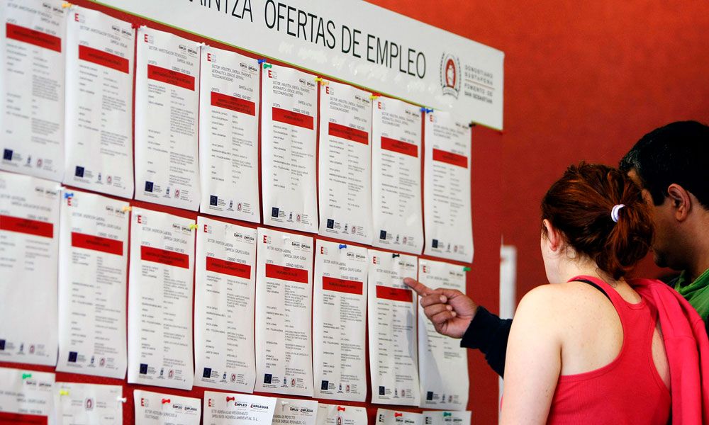 Dos jóvenes leen las ofertas de empleo en un tablón de anuncios