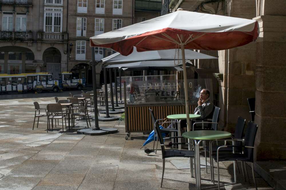 Un hombre fuma en la terraza de un bar