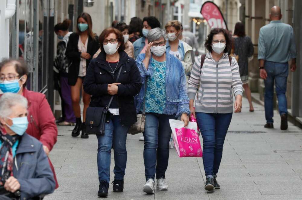 Varias personas con mascarilla caminan por la calle de Viveiro, Lugo. /EFE