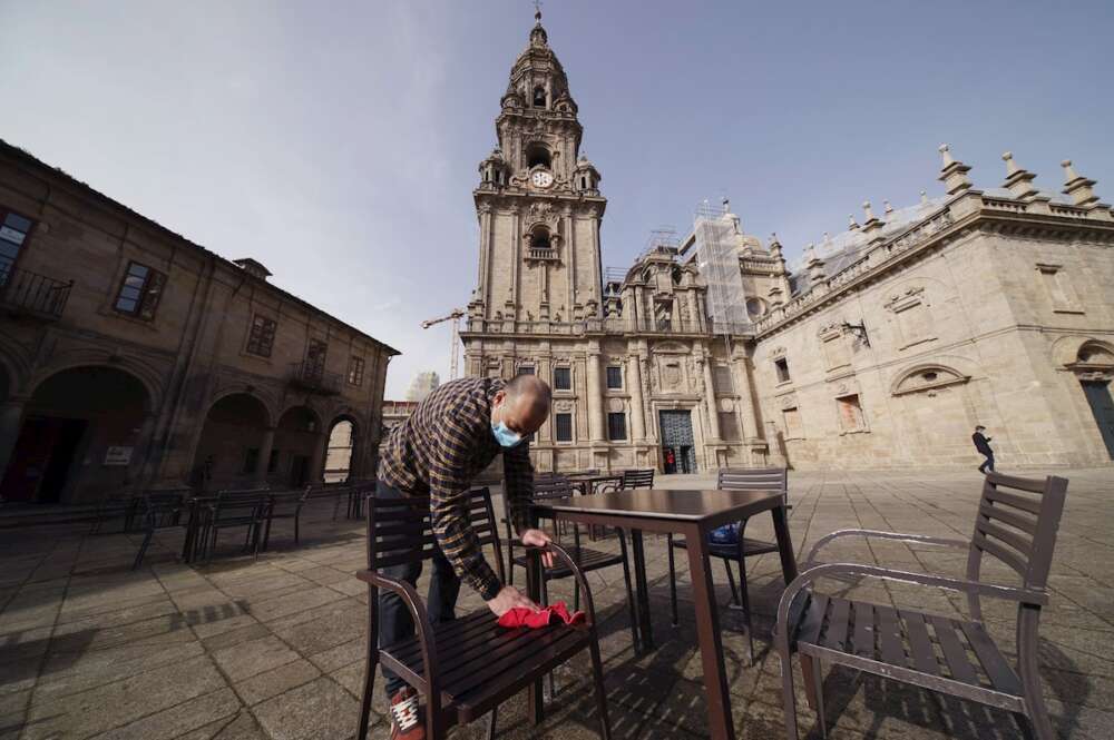 Un hostelero prepara la terraza en la plaza de A Quintana, en Santiago de Compostela. EFE/Lavandeira jr