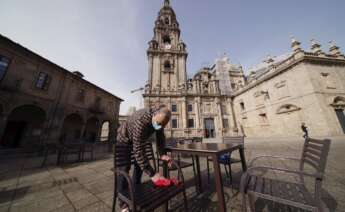 Un hostelero prepara la terraza en la plaza de A Quintana, en Santiago de Compostela. EFE/Lavandeira jr