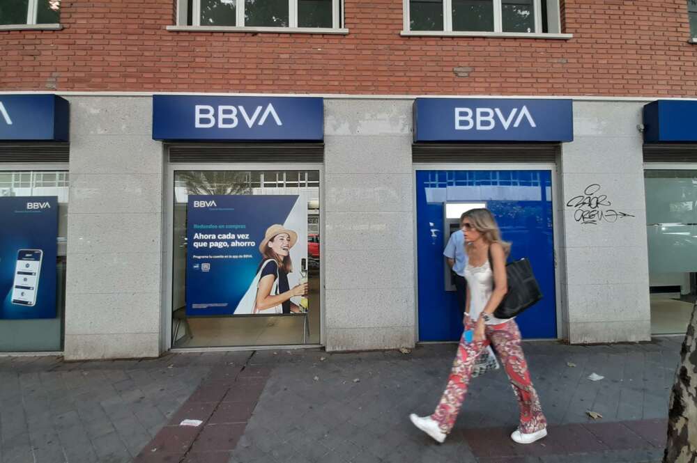 Una mujer pasa una oficina bancaria con el nuevo logo del BBVA en Madrid. - Eduardo Parra - Europa Press - Archivo