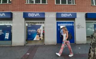 Una mujer pasa una oficina bancaria con el nuevo logo del BBVA en Madrid. - Eduardo Parra - Europa Press - Archivo