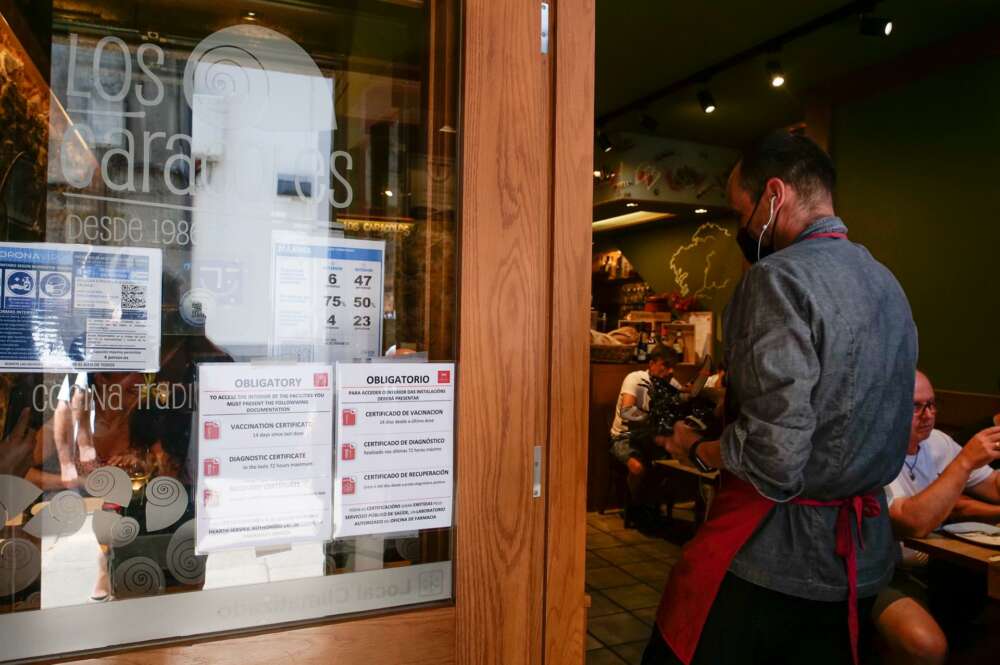 Carteles de indicaciones de obligatoriedad de presentar certificados antes de acceder al interior, en una marisquería de la Rua da Raiña, el día en que el TSXG declara nula la petición de certificado Covid para la hostelería, en Santiago de Compostela - César Arxina