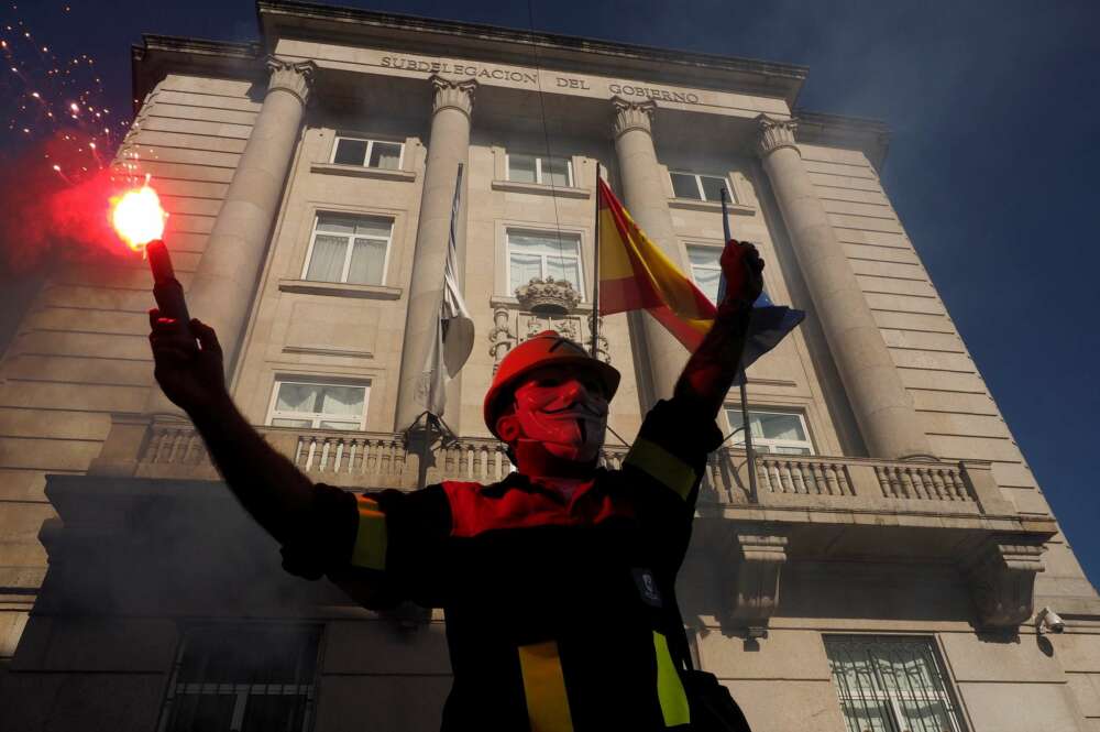 Un manifestante con una bengala delante de la subdelegación del Gobierno, durante la protesta convocada por los trabajadores de Alcoa San Cibrao por la viabilidad de la única fábrica de aluminio primario que queda en España bajo el lema 'A loita continúa'. EFE/Eliseo Trigo