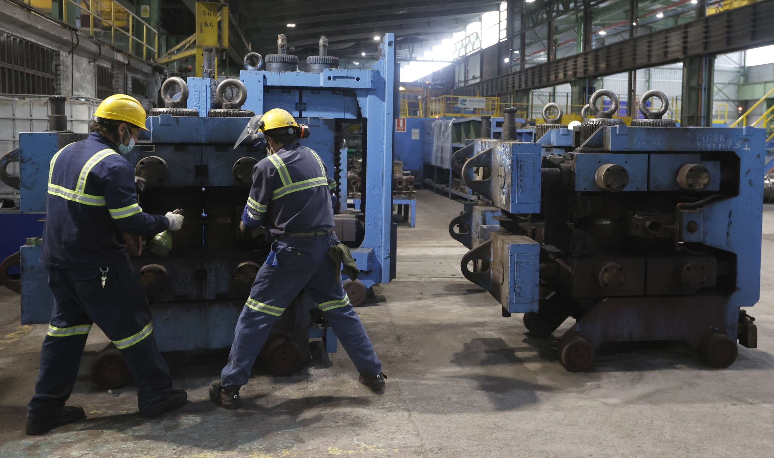 Dos trabajadores ante una máquina en las instalaciones que Sidenor tiene en Basauri. EFE/LUIS TEJIDO