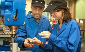 Trabajadores manejando una máquina industrial - INE