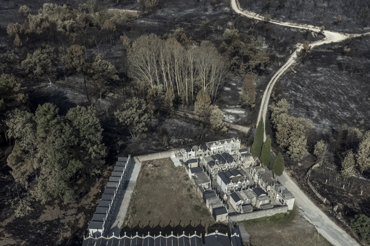 Fotografía tomada con un dron de un cementerio rodeado por la superficie calcinada en el pueblo de San Cibrao (Oímbra), tras el incendio forestal que ha arrasado 2.100 hectáreas. Aunque la situación provocada por los incendios en Galicia ha mejorado en las últimas horas, este viernes continúan los esfuerzos y se mantienen las espadas en alto para evitar que se repitan momentos tan complicados en la lucha contra el fuego como los vividos estos días. EFE/Brais Lorenzo
