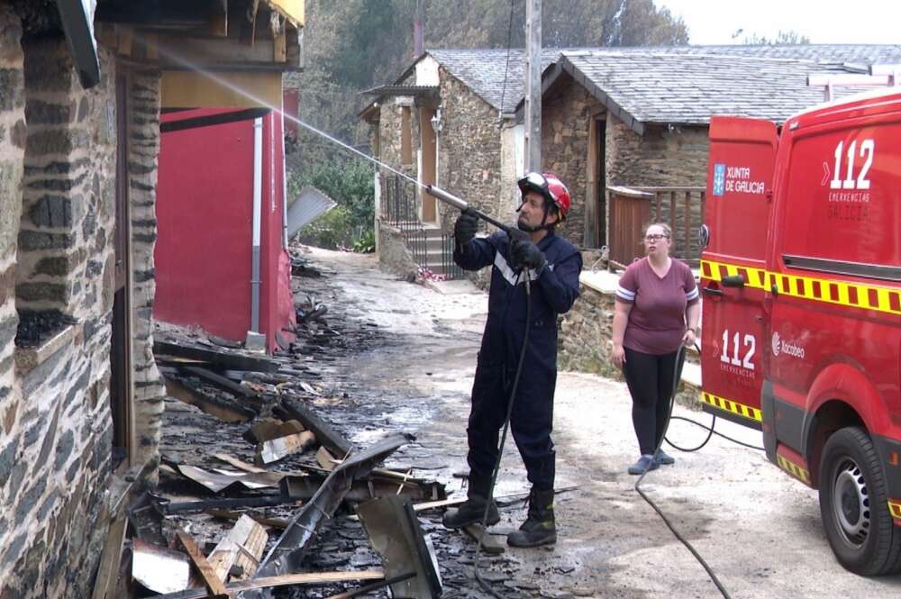 Un bombero enfría una vivienda arrasada por el fuego en Alixo, O Barco de Valdeorras (Ourense). - EUROPA PRESS