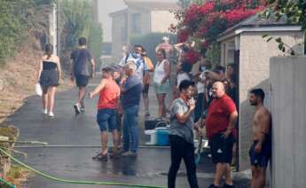 Los vecinos de la parroquia de Meira con cubos de agua y mangueras para sofocar el fuego, a 22 de agosto, en la parroquia de Meira, en Moaña, Pontevedra, Galicia (España)