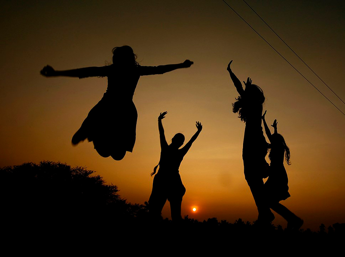 Unos jóvenes saltan durante un atardecer