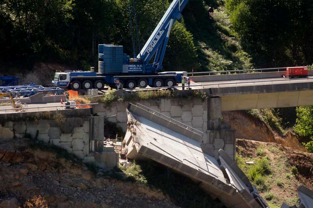 Operarios y grúas trabajan durante el desmontaje del tercer y último vano del viaducto de la A6