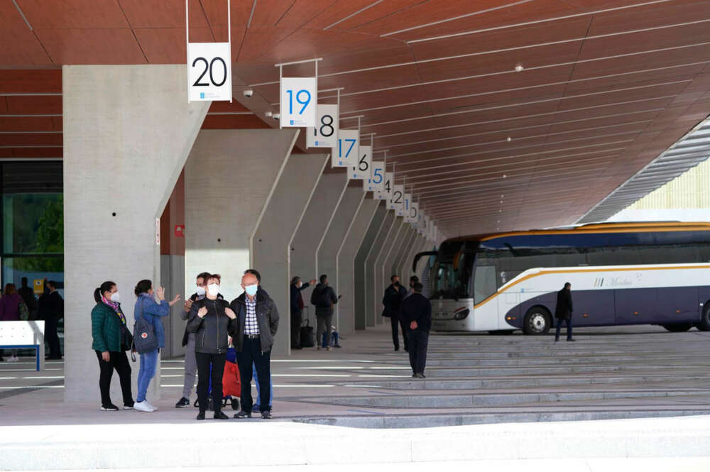 Varias personas esperan autobuses desde una de las dársenas de la estación de autobuses de Santiago de Compostela