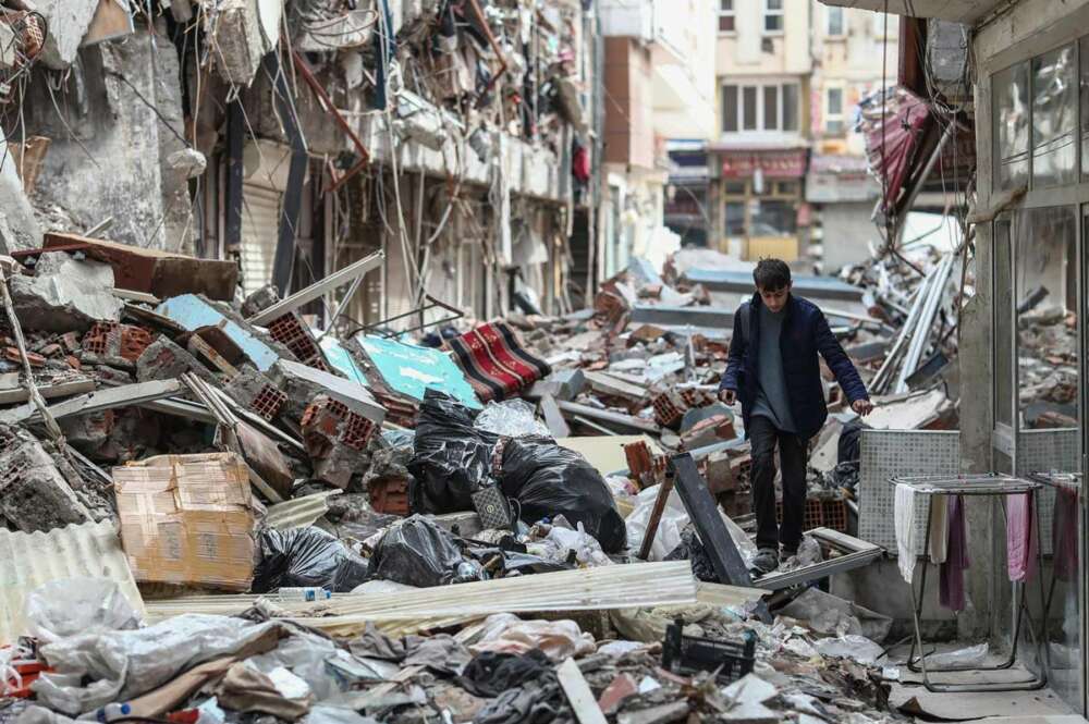 Un niño camina entre edificios derrumbados en la víspera del Ramadán, después de un terremoto en Kahramanmaras, Turquía