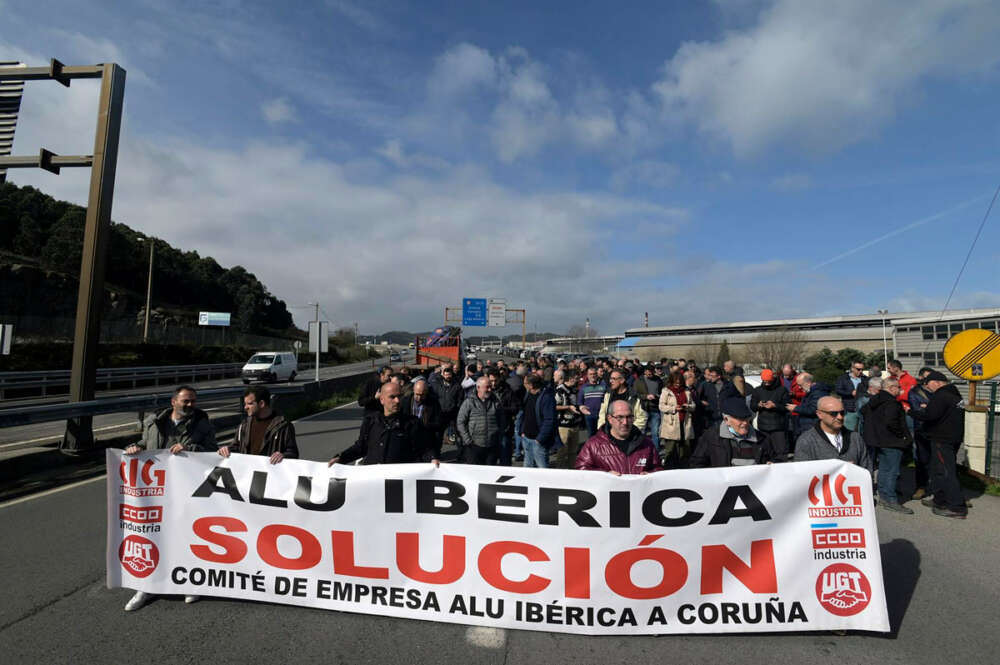 Un grupo de personas protesta con una pancarta durante una concentración frente a la fábrica de Alu Ibérica