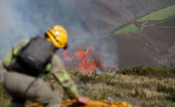 Un efectivo de la Xunta con base en Becerreá trabajan para extinguir las llamas en un incendio forestal en Baleira, Lugo