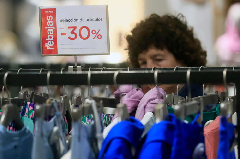 Una mujer mira ropa en un comercio en el primer día del periodo de rebajas