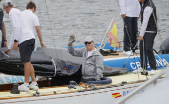 El rey emérito Juan Carlos I saluda desde la embarcación a su llegada este jueves al Real Club Náutico de Sanxenxo, tras haber viajado hasta la localidad para preparar la regata en la que pretende participar este fin de semana en la localidad gallega. EFE/Lavandeira Jr