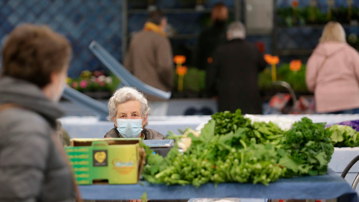 Una mujer en un puesto local de verduras y productos del campo de Lugo