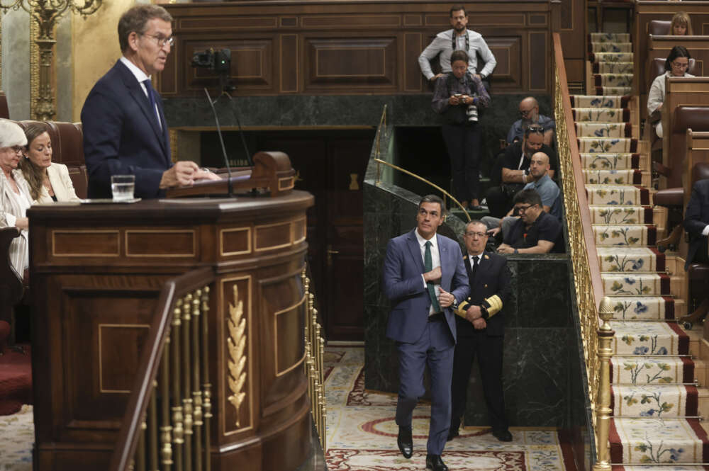 El presidente del Partido Popular y candidato a la investidura, Alberto Núñez Feijóo (i), interviene mientras pasa el presidente del Gobierno en funciones, Pedro Sánchez (d), en la primera sesión de su debate de investidura a la Presidencia del Gobierno, este martes en el Congreso. EFE/Kiko Huesca