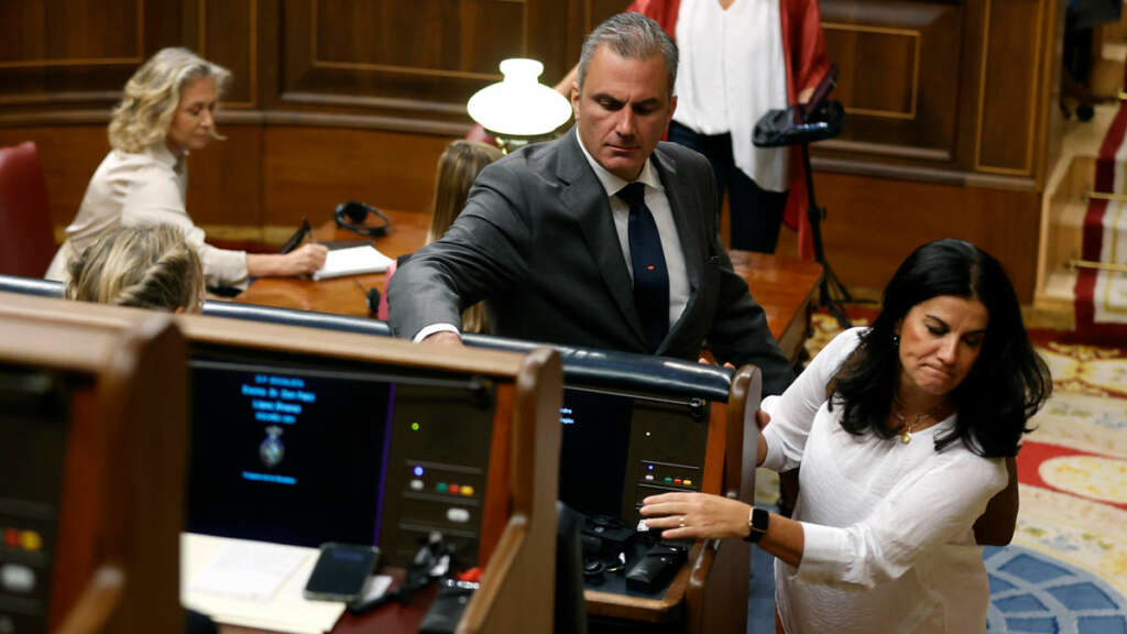 El diputado de VOX, Francisco Ortega Smith deposita su auricular de traducción en el escaño del presidente del Gobierno en funciones, Pedro Sánchez