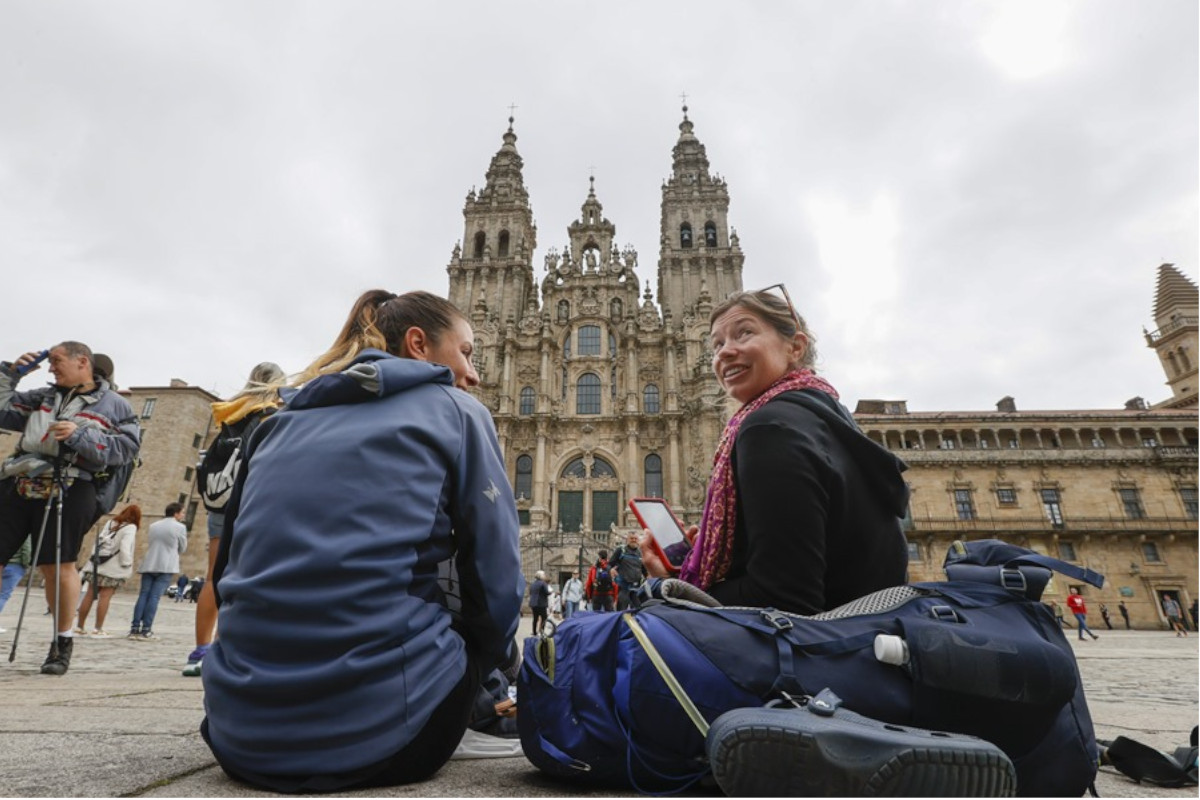 Dos turistas sentadas en la Praza do Obradoiro de Santiago / EFE