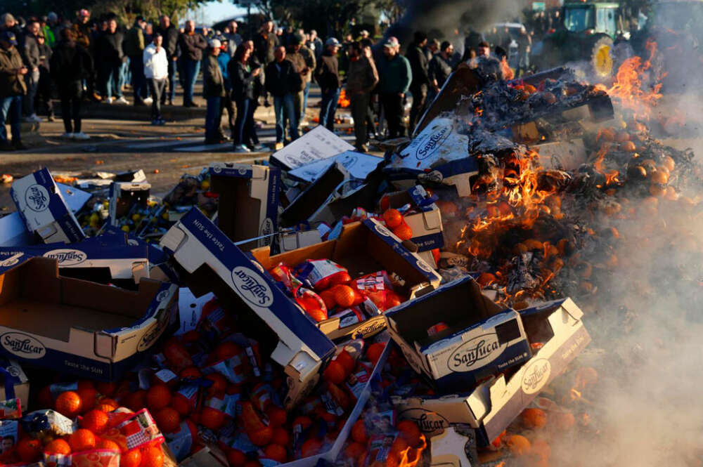 Agricultores franceses queman frutas españolas durante una manifestación en la que han bloqueado la autopista A9 en Nîmes, en el sur de Francia, este 25 de enero de 2024 en demanda de mejores precios