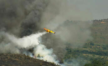 Un avión apaga fuegos de la UME sobrevuela y vierte agua sobre el incendio de Cualedro (Ourense)