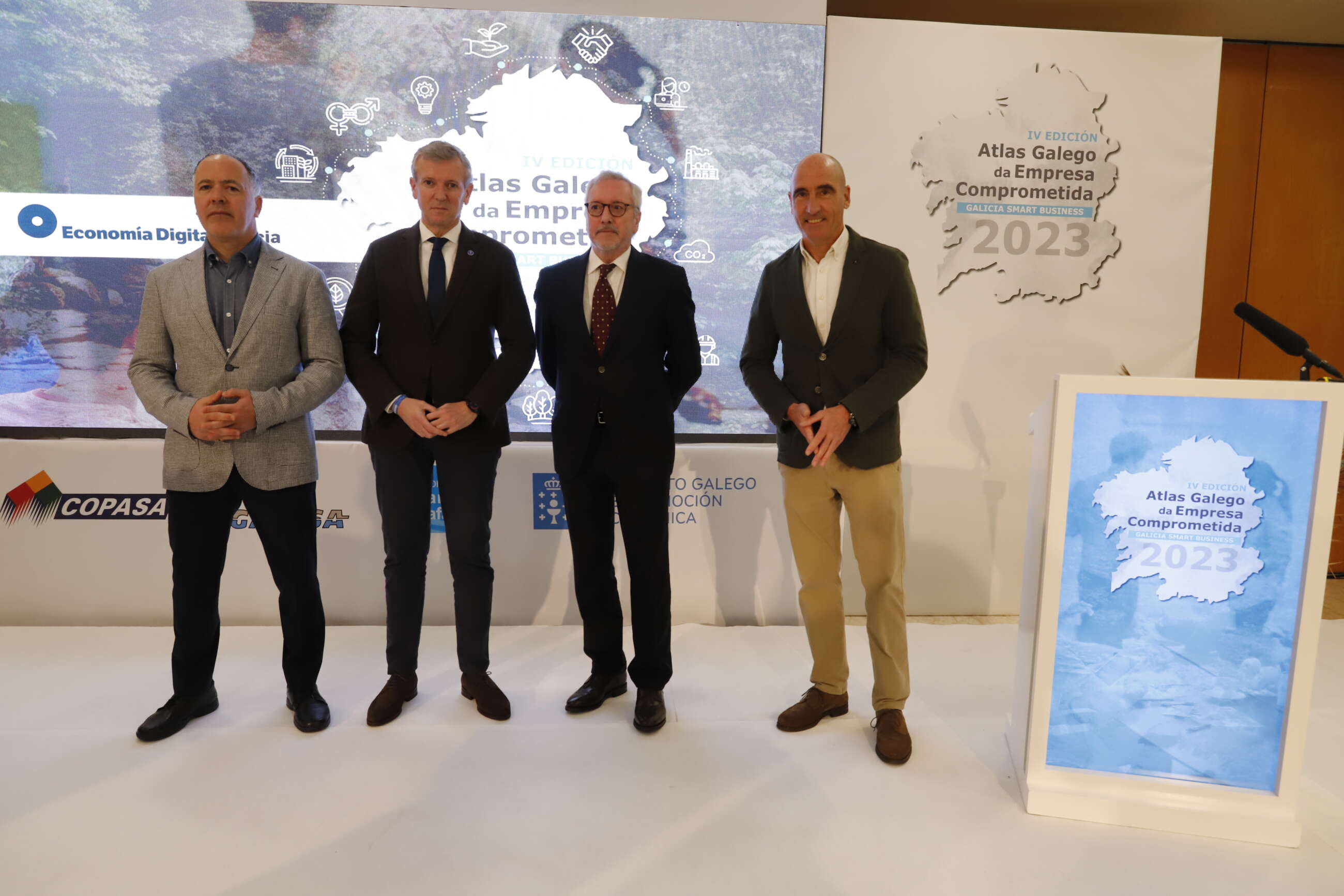 El presidente en funciones de la Xunta, Alfonso Rueda, antes de comenzar el acto, flanqueado por Juan García y Julián Rodríguez, CEO y director de Economía Digital Galicia, a la derecha, y por el economista Marcelino Fernández Mallo