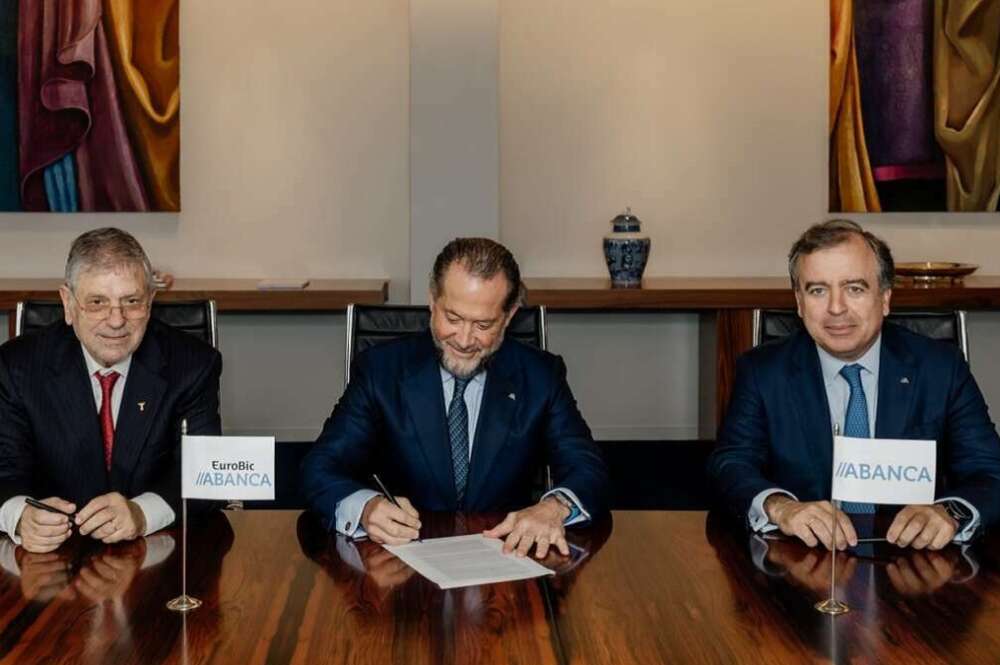 Juan Carlos Escotet (centro) y Francisco Botas (derecha), presidente y consejero delegado de Abanca en la firma, en julio del año pasado, de la adquisición de la financiera lusa Eurobic