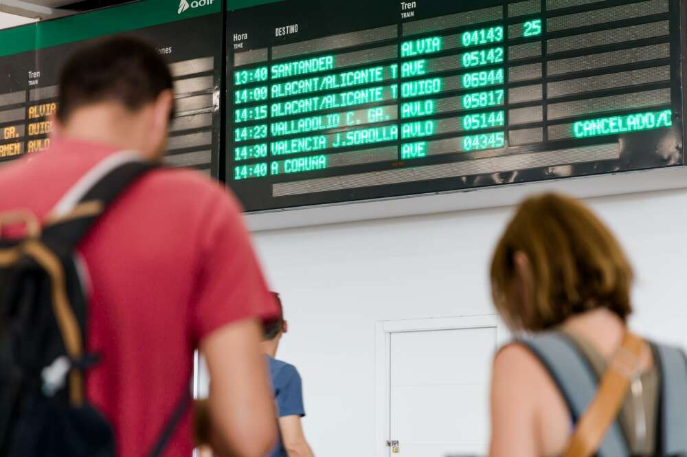 Varias personas esperan con maletas, junto a los carteles de salidas, en la estación Chamartín Clara Campoamor / Europa Press