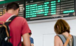 Varias personas esperan con maletas, junto a los carteles de salidas, en la estación Chamartín Clara Campoamor / Europa Press