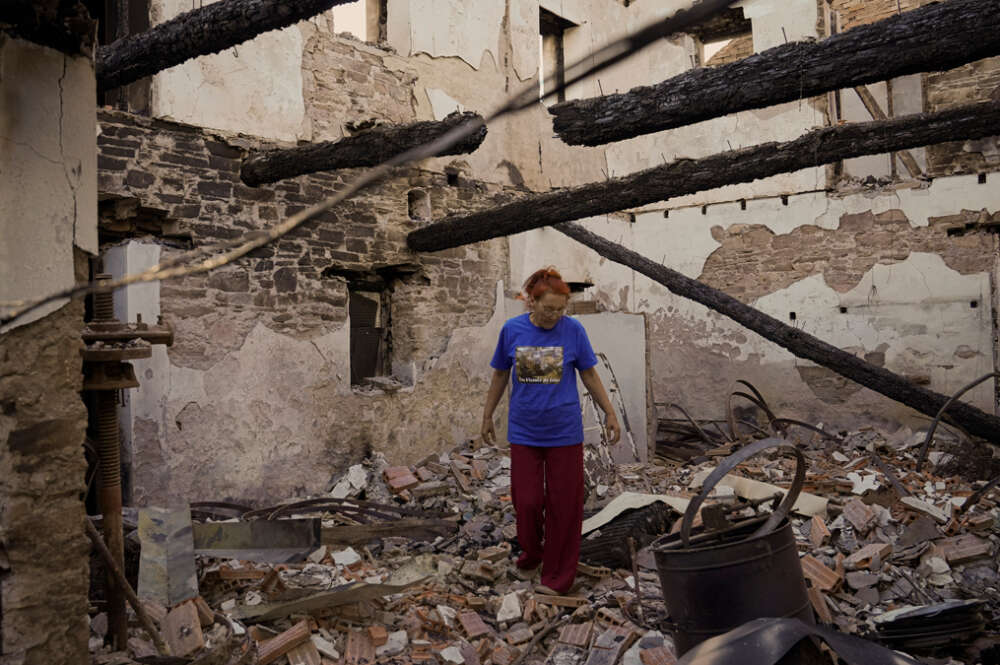 Una mujer observa su casa destruida por el incendio, a 20 de agosto de 2025, en San Vicente de Arriba, Ourense, Galicia (España).