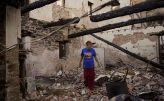 Una mujer observa su casa destruida por el incendio, a 20 de agosto de 2025, en San Vicente de Arriba, Ourense, Galicia (España).