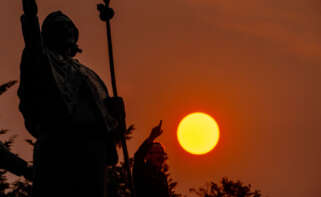 Un peregrino camina durante la salida del sol en el Monte do Gozo, en Santiago de Compostela.