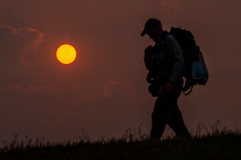 Un peregrino camina durante la salida del sol en el Monte do Gozo