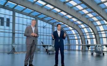 Ángel Escribano y José Vicente de los Mozos, presidente y CEO de Indra, en un montaje con el hangar de la compañía en Rozas de fondo