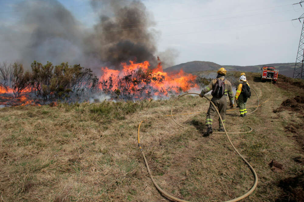 Efectivos de la Xunta con base en Becerreá trabajan para extinguir las llamas en un incendio forestal en Baleira, Lugo.