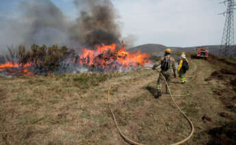 Efectivos de la Xunta con base en Becerreá trabajan para extinguir las llamas en un incendio forestal en Baleira, Lugo.