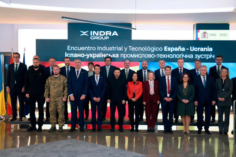 El presidente de Ucrania, Volodímir Zelenski (centro), junto a la ministra de Defensa, Margarita Robles, en la sede de Indra en el marco del encuentro con 13 empresas del sector de la defensa española