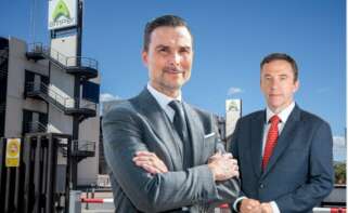 El CEO de Amper, Enrique López, y el presidente de Navantia, Ricardo Domínguez, en un montaje con la sede de Amper de fondo