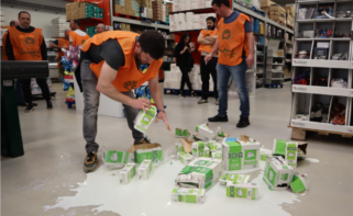 Protesta de ganaderos de Unións Agrarias, que arrojan leche de Clun en un establecimiento comercial / Unións Agrarias