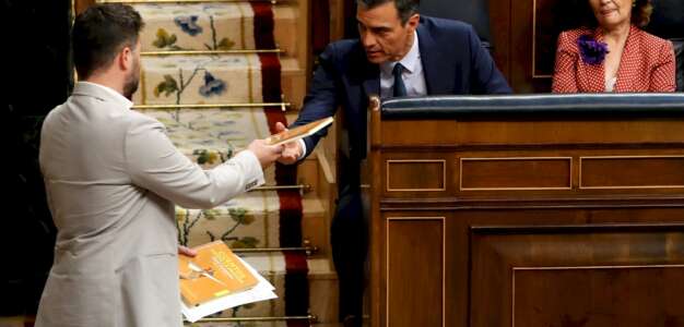 El portavoz de ERC, Gabriel Rufián, de pie, entregando a Sánchez un ejemplar del libro de cuentos escrito por Junqueras en prisión en julio. Foto: EFE/Ballesteros
