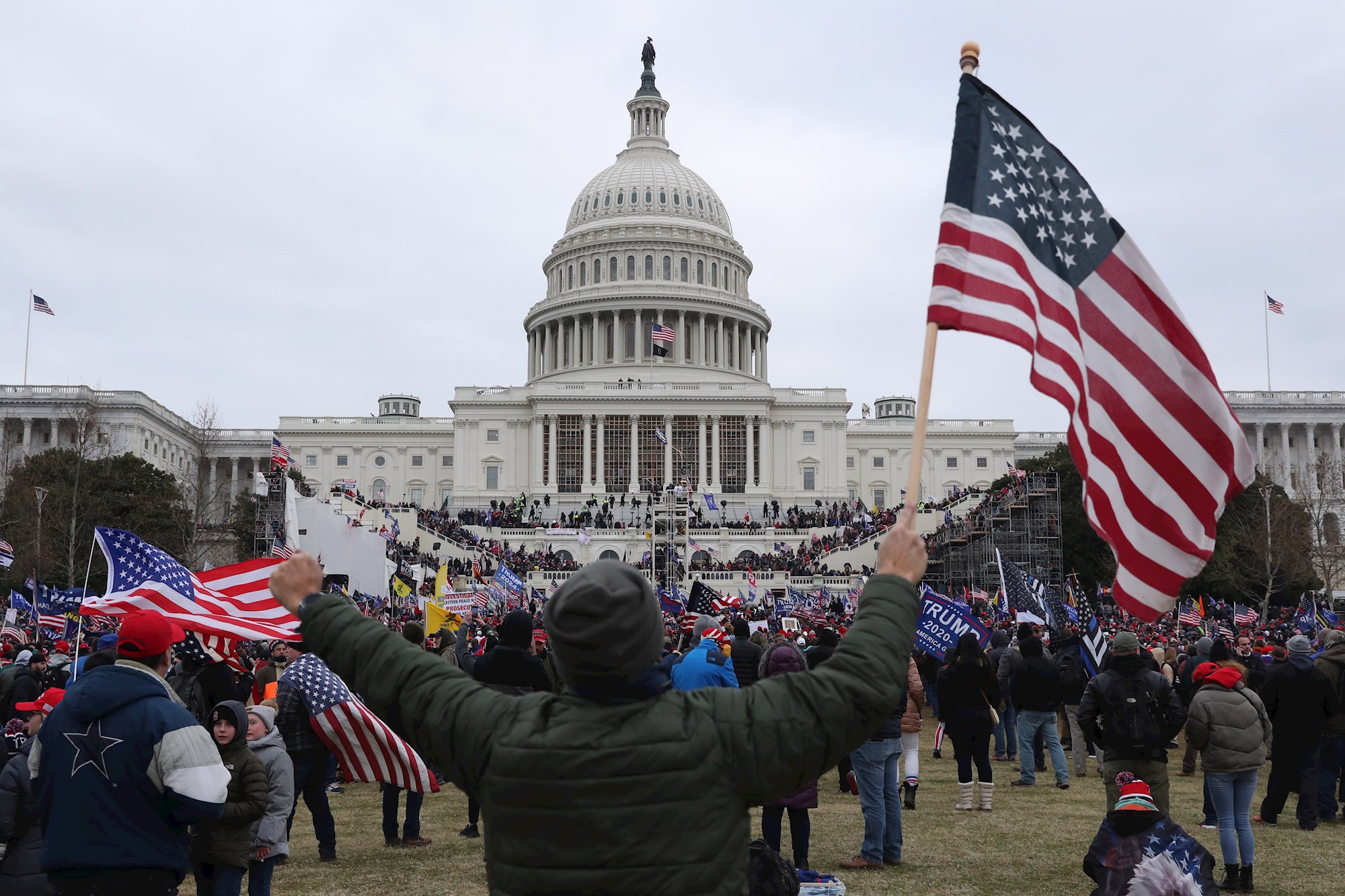 De fascistas, franquicias de Trump, reincidencias e indultos 1 Un seguidor de Donald Trump sostiene la bandera de los Estados Unidos frente al Capitolio estadounidense, el 6 de enero de 2021 | EFE/MR/Archivo